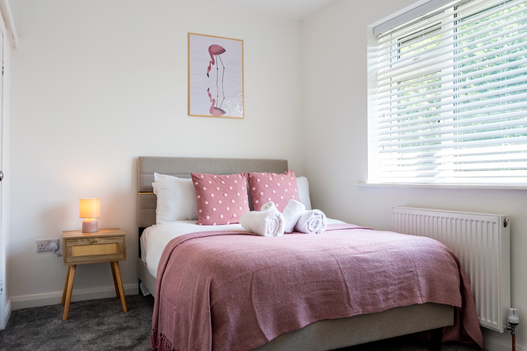 Lord Lodge double bedroom with pink throw and bedside table